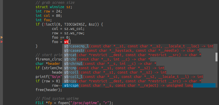 A C code file, with the letters st are written. A pop-up below the cursor displays options like strcat, strchr, strcmp and more.